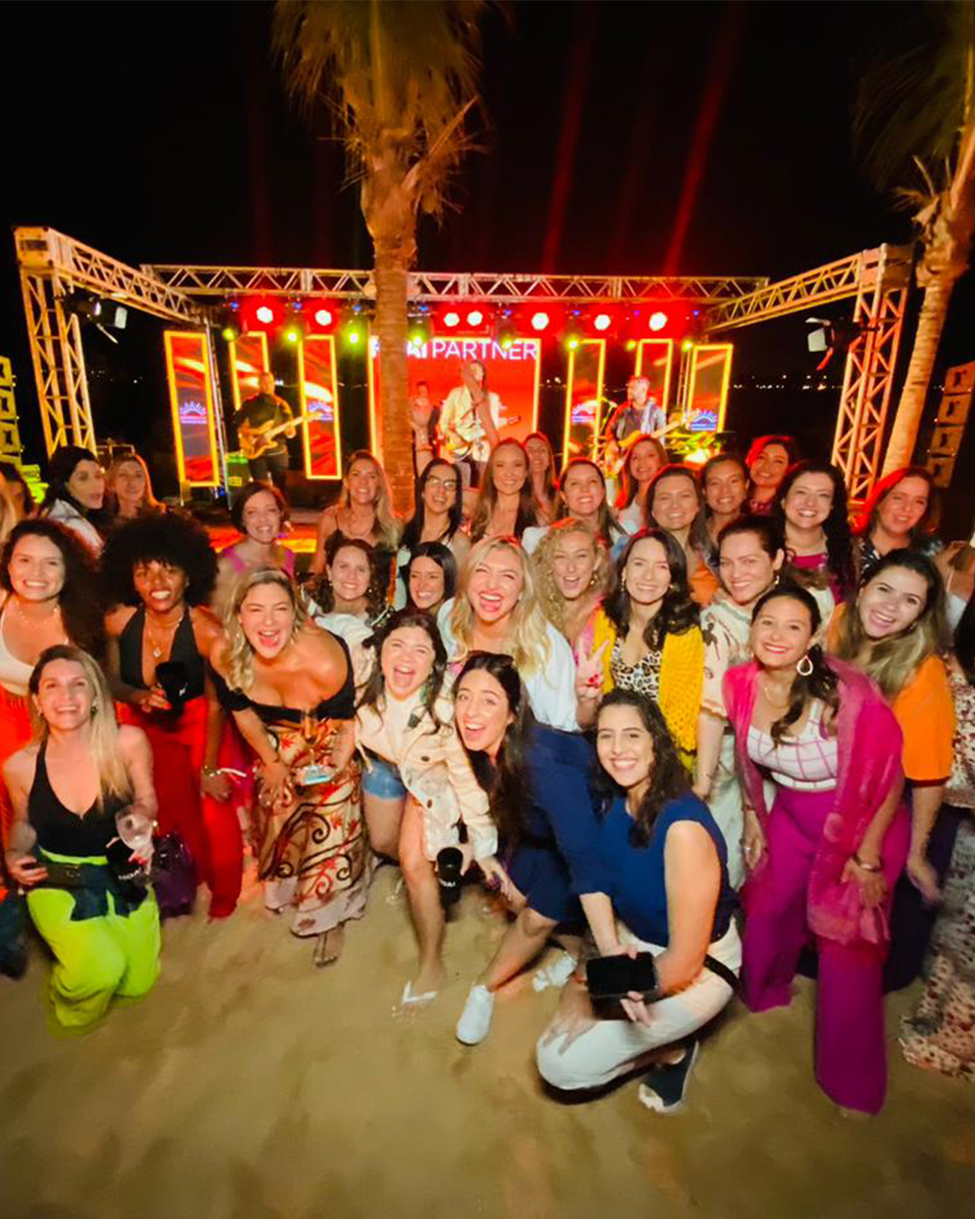 Grupo grande de mulheres reunidas e sorrindo durante encontro de empreendedorismo